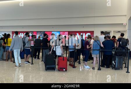 Am Avis-Schalter im Salt Lake City International Airport-Mietwagenzentrum warten Menschen in der Schlange, inmitten der globalen Coronavirus-Pandemie COVID-19, S Stockfoto