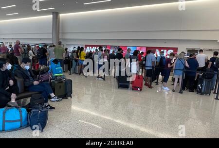 Am Avis-Schalter im Salt Lake City International Airport-Mietwagenzentrum warten Menschen in der Schlange, inmitten der globalen Coronavirus-Pandemie COVID-19, S Stockfoto