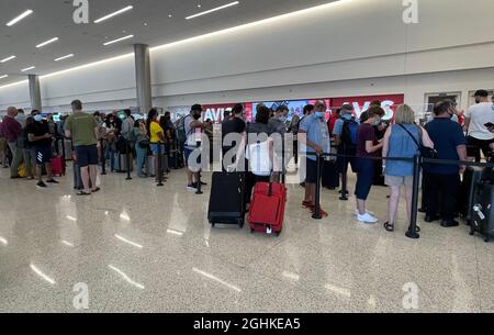 Am Avis-Schalter im Salt Lake City International Airport-Mietwagenzentrum warten Menschen in der Schlange, inmitten der globalen Coronavirus-Pandemie COVID-19, S Stockfoto