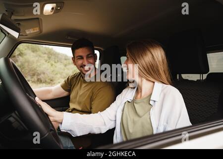 Schönes junges Paar, das auf Beifahrersitzen sitzt und ein Auto fährt Stockfoto