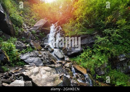 Bergwasserfall. Wasser fließt über Felsen. Schnell strömend Wasser. Sommerlandschaft Stockfoto