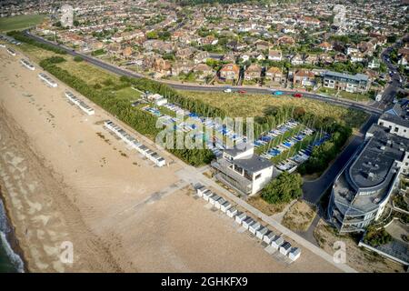 Luftaufnahme des Goring by Sea Strandes mit Segeljollen im Blick auf den Yacht Club hinter den Strandhütten. Stockfoto