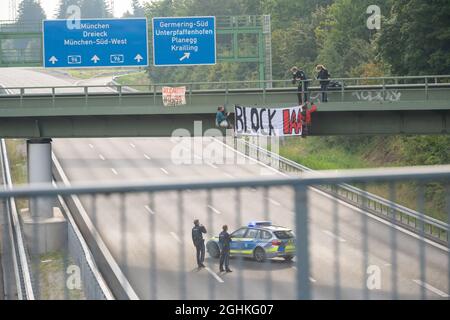 München, Deutschland. September 2021. Aktivisten nehmen an einer Banneraktion auf einer Brücke über die Autobahn A96 bei Gererring Teil. Auf dem Banner steht 'Block IAA'. Kredit: Peter Kneffel/dpa/Alamy Live Nachrichten Stockfoto