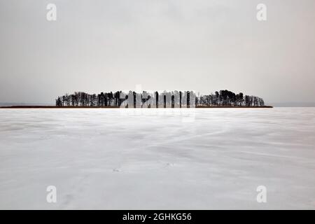 Baltezers, Lettland: Kleine Insel in einem gefrorenen See im verschneiten Winter Stockfoto