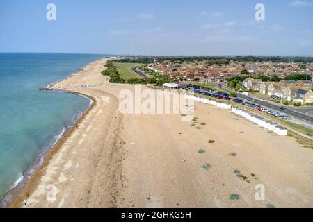 Goring by Sea Beach mit dem Sea Lane Cafe im Blick und dem grünen Strand hinter dem Strand in diesem beliebten Badeort. Luftaufnahme. Stockfoto