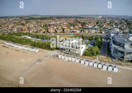 Luftaufnahme von Goring by Sea und Marine Crescent, die hinter dem Sailing Club und den Strandhütten läuft. Stockfoto