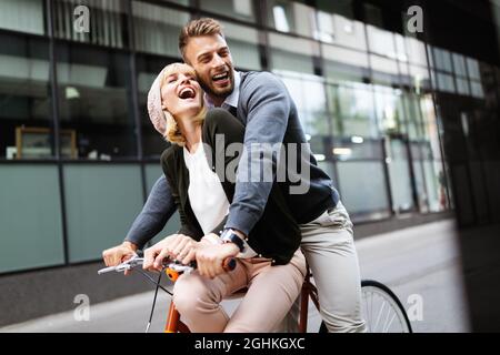 Porträt eines fröhlichen jungen Paares, das mit dem Fahrrad unterwegs ist und gemeinsam im Freien Spaß macht Stockfoto