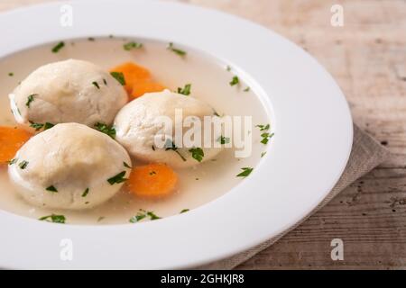 Traditionelle jüdische Matzah-Kugelsuppe auf Holztisch Stockfoto