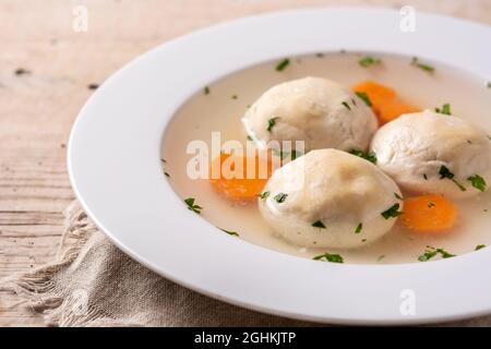 Traditionelle jüdische Matzah-Kugelsuppe auf Holztisch Stockfoto