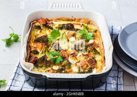 Quiche Pie mit Lachs und Brokkoli in Backform, Nahaufnahme. Stockfoto