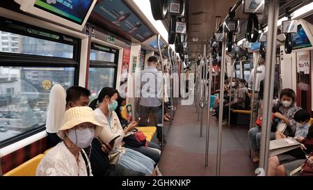 Im BTS Skytrain Coach während Pandemie Menschen tragen Gesichtsmaske Stockfoto