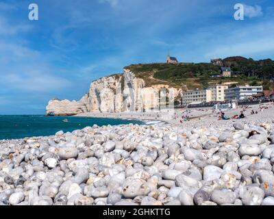 Etretat, Frankreich, Normandie.Strände mit Kieselsteinen Blick von unten auf die weißen Kilfen die größte Touristenattraktion in Etretat. Menschen am Strand und Stockfoto