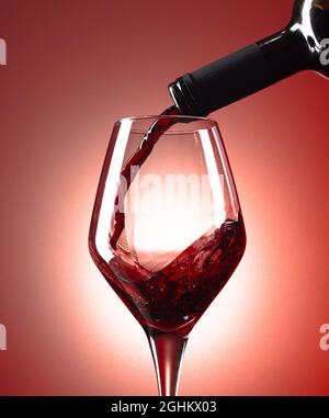 Rotwein in ein Glas Wein gegossen wird. Stockfoto