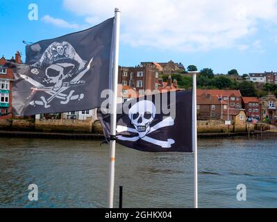 Jolly Roger Totenkopf- und Kreuzknochen-Fahnen für Vergnügungsfahrten auf Booten in Whitby Harbour Stockfoto