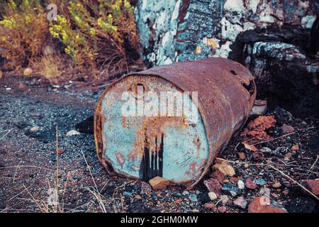 Bidón de Metal deteriado, en balsa de alquitrán y terreno contaminado Stockfoto