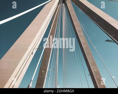 Rion-Antirion Brücke Bau Stahlturm mit Drähten auf Autobahn Straße, Griechenland. Suspension, die zweitlängste Seilbrücke auf sonnigem, landschaftlich schönem Blau Stockfoto