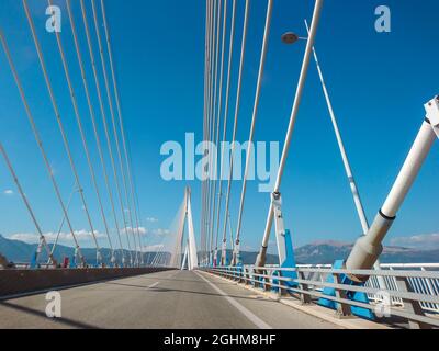 Fahren der Rion-Antirion Brücke auf der Autobahn in Patras Stadt, Griechenland. Hängebrücke am Golf von Korinth. Die zweitlängste Brücke mit Kabelgestabeung. Sonnensumpf Stockfoto