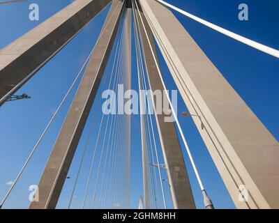 Rion-Antirion Brücke Bau Stahlturm mit Drähten auf Autobahn Straße, Griechenland. Suspension, die zweitlängste Seilbrücke auf sonnigem, landschaftlich schönem Blau Stockfoto