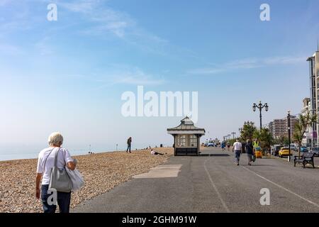 Menschen, die im September 2021 die Promenade in Worthing, West Sussex, entlang laufen Stockfoto