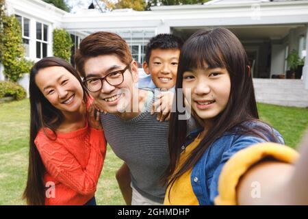 Porträt glücklicher asiatischer Eltern, Sohn und Tochter, die im Garten lächeln Stockfoto