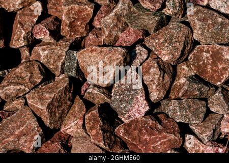 Es gibt viele braune und orangefarbene Granitsteine. Steinstruktur. Stockfoto