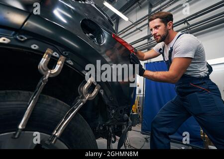 Der Mensch schiebt das Rücklicht des Autos von hinten Stockfoto