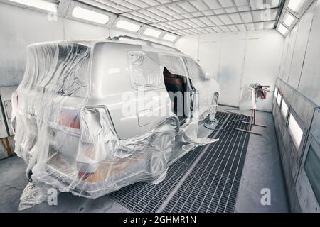 Transporter mit Folie bedeckt, in der Spritzkabine stehend Stockfoto