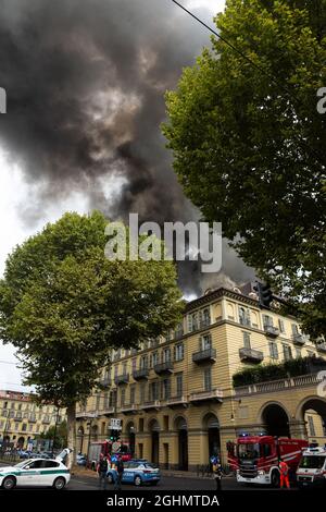 Das Feuer in Turin zerstört den historischen Palast gegenüber dem Bahnhof Porta Nuova. Die Feuerwehrleute werden aktiviert und arbeiten unaufhörlich daran, das Feuer im zu löschen Stockfoto