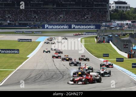 Fernando Alonso (ESP) Ferrari F2012 führt am Start des Rennens an, als Sebastian Vettel (GER) Red Bull Racing RB8 und Michael Schumacher (GER) Mercedes AMG F1 W03 um den zweiten Platz kämpfen. 22.07.2012. Formel 1 Weltmeisterschaft, Rd 10, Großer Preis Von Deutschland, Hockenheim, Deutschland, Wettkampftag Stockfoto