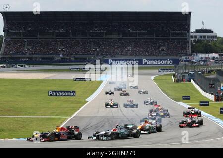 Sebastian Vettel (GER) Red Bull Racing RB8 und Michael Schumacher (GER) Mercedes AMG F1 W03 kämpfen beim Start um den zweiten Platz. 22.07.2012. Formel 1 Weltmeisterschaft, Rd 10, Großer Preis Von Deutschland, Hockenheim, Deutschland, Wettkampftag Stockfoto