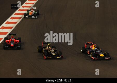 Sebastian Vettel (GER) Red Bull Racing RB8 kämpft mit Romain Grosjean (FRA) Lotus F1 E20 und Charles Pic (FRA) Marussia F1 Team MR01. 04.11.2012. Formel-1-Weltmeisterschaft, Rd 18, Abu Dhabi Grand Prix, Yas Marina Circuit, Abu Dhabi, Race Day. Stockfoto