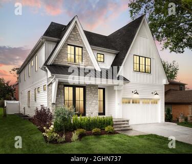 Ein neues, weißes, modernes Bauernhaus mit Felswänden bei Sonnenuntergang. Stockfoto