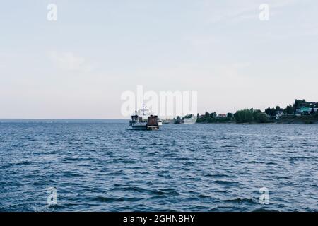 Boot im Meer. Einzelboot am Horizont am Meer. Seereise mit dem Boot. Ruhe am Meer. Fischerboot am Fluss. Handelsbeziehungen auf See Stockfoto