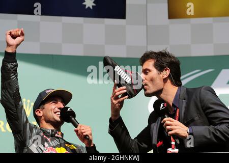 (L bis R): Daniel Ricciardo (AUS) Red Bull Racing feiert seinen zweiten Podiumsplatz mit Mark Webber (AUS) Porsche Team WEC Driver / Channel 4 Presenter, der Champagner von Daniels Rennschuh trinkt. 28.08.2016. Formel-1-Weltmeisterschaft, Rd 13, Großer Preis Von Belgien, Spa Francorchamps, Belgien, Wettkampftag. Bildnachweis sollte lauten: XPB/Press Association Images. Stockfoto