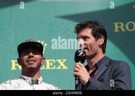 (L bis R): Lewis Hamilton (GBR) Mercedes AMG F1 auf dem Podium mit Mark Webber (AUS) Porsche Team WEC Driver / Channel 4 Presenter. 28.08.2016. Formel-1-Weltmeisterschaft, Rd 13, Großer Preis Von Belgien, Spa Francorchamps, Belgien, Wettkampftag. Bildnachweis sollte lauten: XPB/Press Association Images. Stockfoto