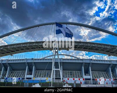 Ikonische Ansicht des Olympiastadions OAKA in Athen, Griechenland, entworfen von Santiago Calatrava mit wunderschönen Wolken und blauem Himmel Stockfoto