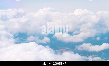 Luftaufnahme von atemberaubenden, flauschigen Wolken, die so weiß wie Schnee am blauen Himmel sind, während der Tagesaufnahme über Spanien. Wolkenlandschaft. Verträumter Hintergrund. Stockfoto