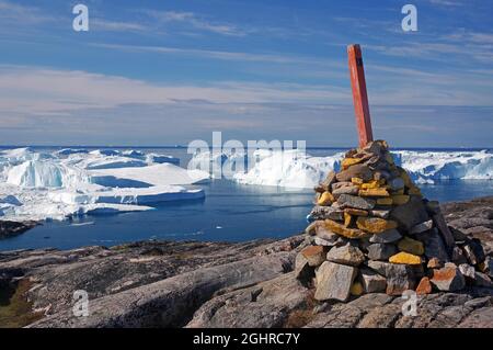 Wandermarker, große Kaimne auf Felsen über mit Eisbergen bedeckten Fjord, Ilulissat, Grönland, Nordamerika, Dänemark Stockfoto