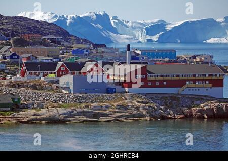 Gebäude vor Eisbergen, karge Landschaft, Disko Bay, Ilulissat, Arktis, Grönland, Dänemark Stockfoto