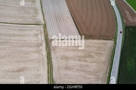 Drohnenschuss, Straße durch grüne und geerntete Felder bei Waldzell im Innviertel, Agrarlandschaft, Oberösterreich, Österreich Stockfoto