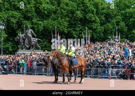 Zwei Polizisten zu Pferd, eine Menge Touristen, die den traditionellen Wachwechsel und den Wachwechsel vor dem Buckingham Palace beobachten Stockfoto