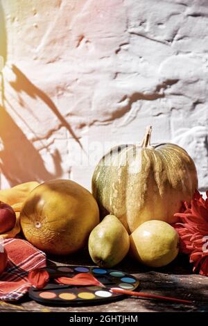 Herbstliches Stillleben im rustikalen Stil: Gelbe Früchte, Gemüse und helle Farben, Kürbis, Birnen, Apfel und Melone. Thanksgiving Day Konzept. Herbst ae Stockfoto