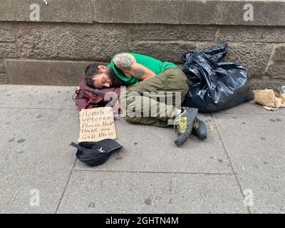 Kriegsopfer: Obdachloser US-Militärveteran schläft auf der Straße und bittet Bryant Park in Midtown Manhattan, New York City, um Hilfe. Stockfoto