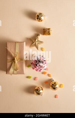 Weihnachtskarte. Cupcake mit Geschenkboxen, Ornament und Bonbons auf gelben Hintergrund. Urlaub. Stockfoto