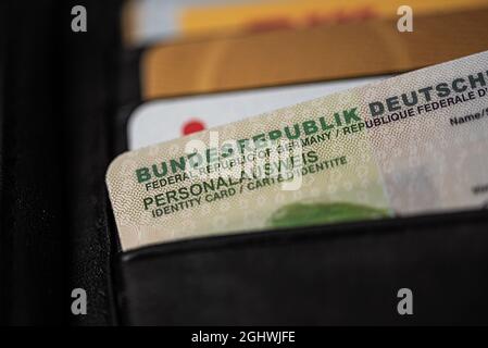 Extreme Nahaufnahme des deutschen Personalausweises in schwarzer Ledertasche Stockfoto