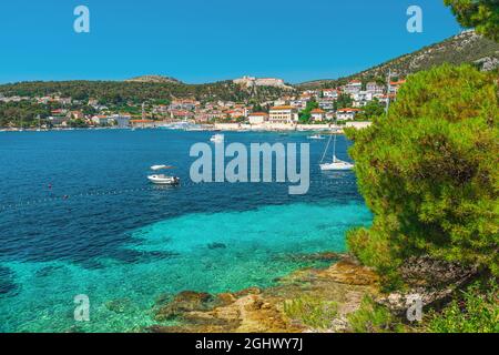 Türkisfarbenes Wasser der Adria auf der Insel Hvar und der Altstadt von Hvar in Dalmatien, Kroatien. Urlaubsziel im Sommer Stockfoto