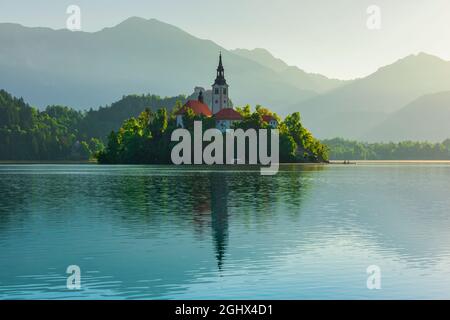 Schöner Blick auf die Wallfahrtskirche Mariä Himmelfahrt auf einer kleinen Insel am Bleder See, Slowenien bei Sonnenaufgang. Reiseziel Stockfoto