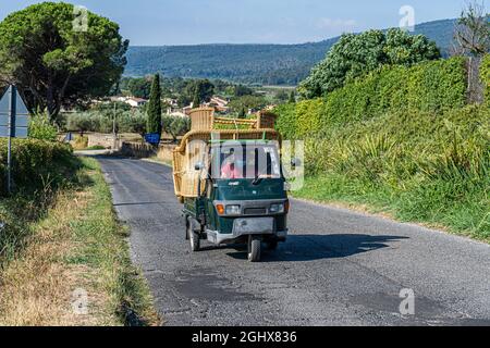 Ein dreirädriger Piaggio Ape 50 in Green Sherwood transportiert Möbel auf dem italienischen Land Stockfoto