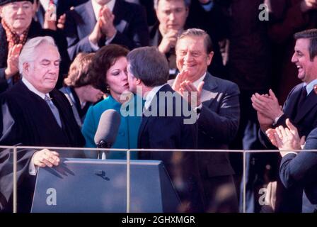 US-Präsident Jimmy Carter küsst Frau Rosalynn Carter, nachdem er den Amtseid des Präsidenten der Vereinigten Staaten vom East Portico des US-Kapitols, Washington, D.C., USA, 20. Januar 1977 Stockfoto