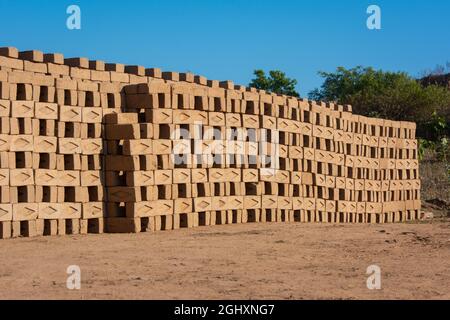 Handgemachte Ziegel aus nassem Ton und Schlamm werden vor dem Brennvorgang zum Trocknen aufbewahrt. Traditionelle Herstellung von Ziegelsteinen in Indien. Stockfoto